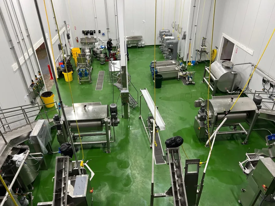 Production floor of the Northgate Markets commissary: mixers, kettles and screw conveyors